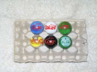 Six various Coca Cola logo marbles with stands last ones  